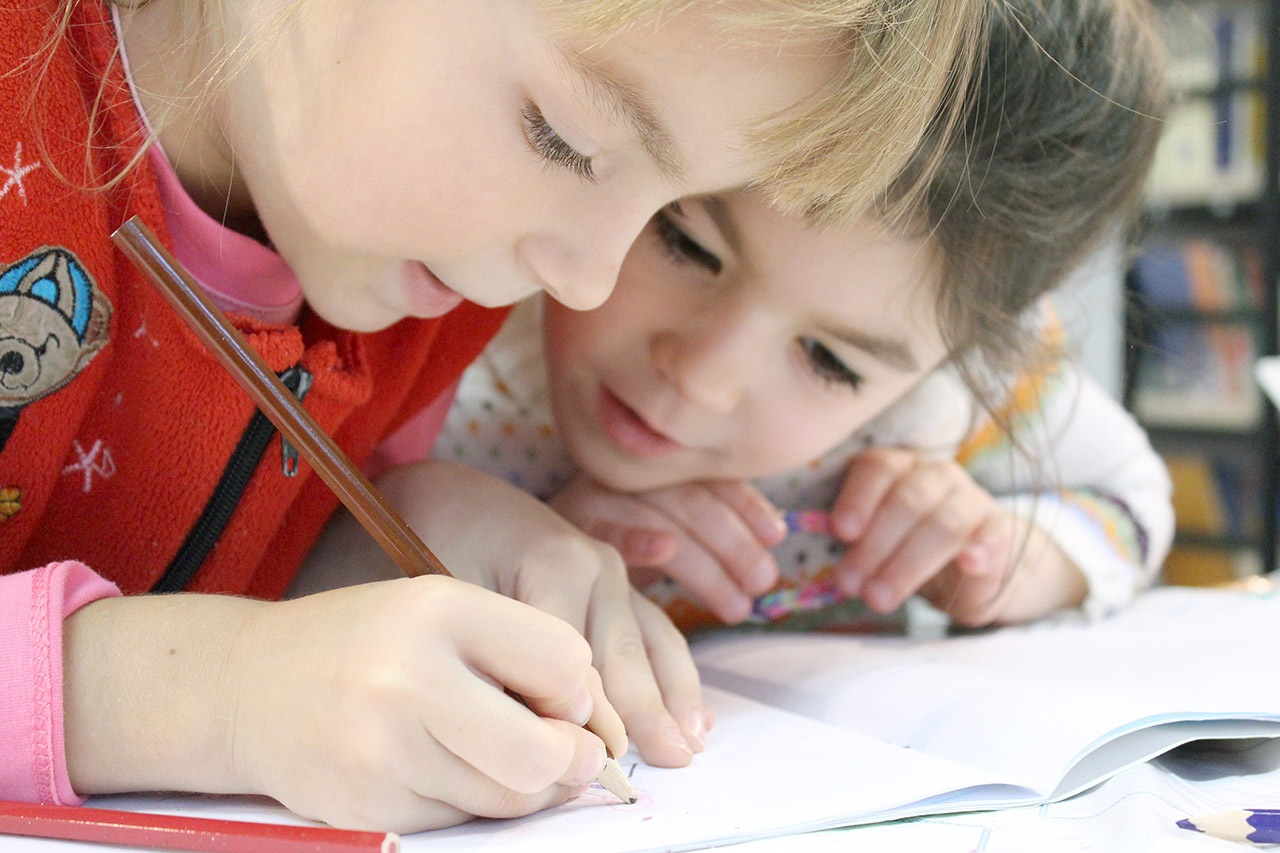 Nenes dibuixant en un quadern